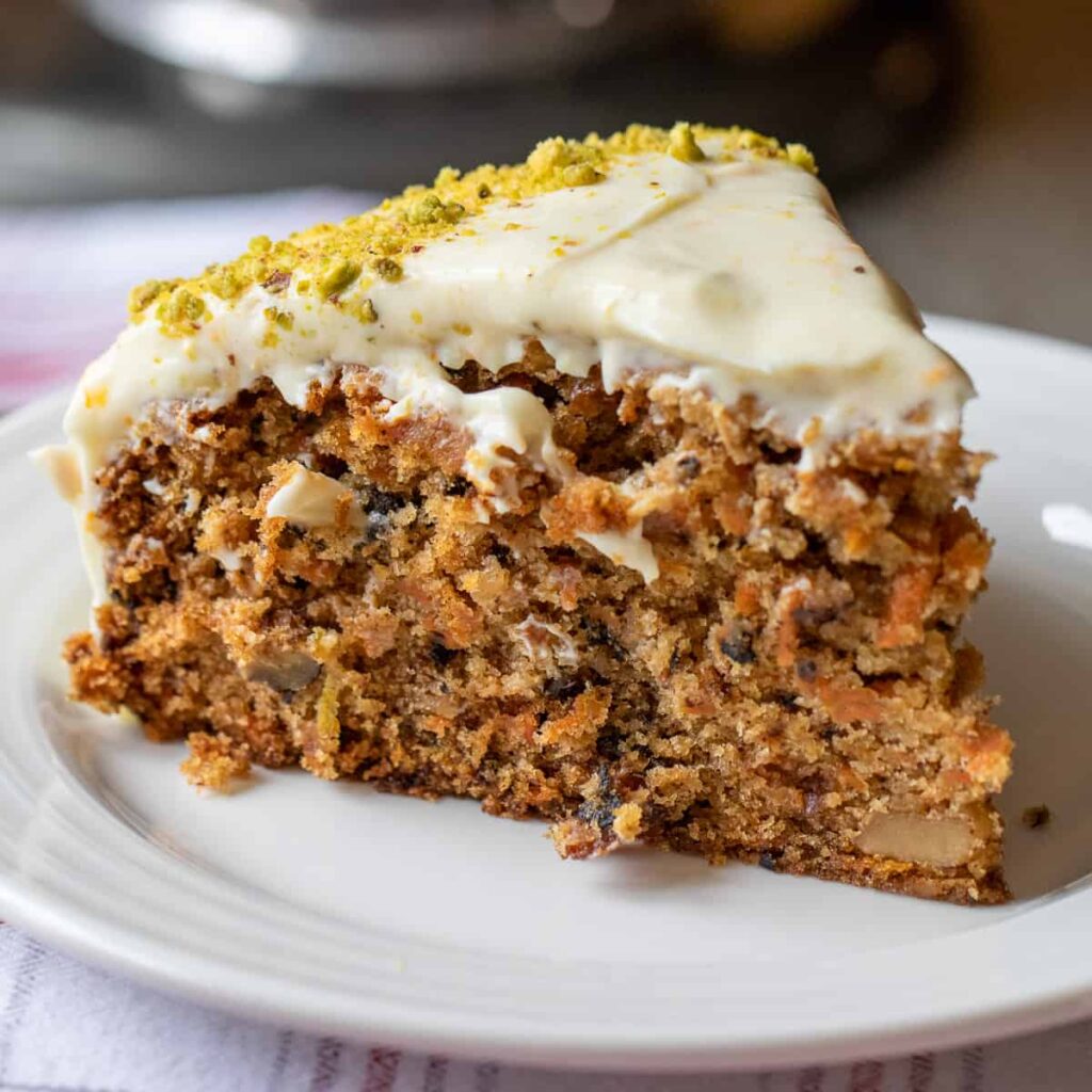 A slice of carrot cake served on a white plate.