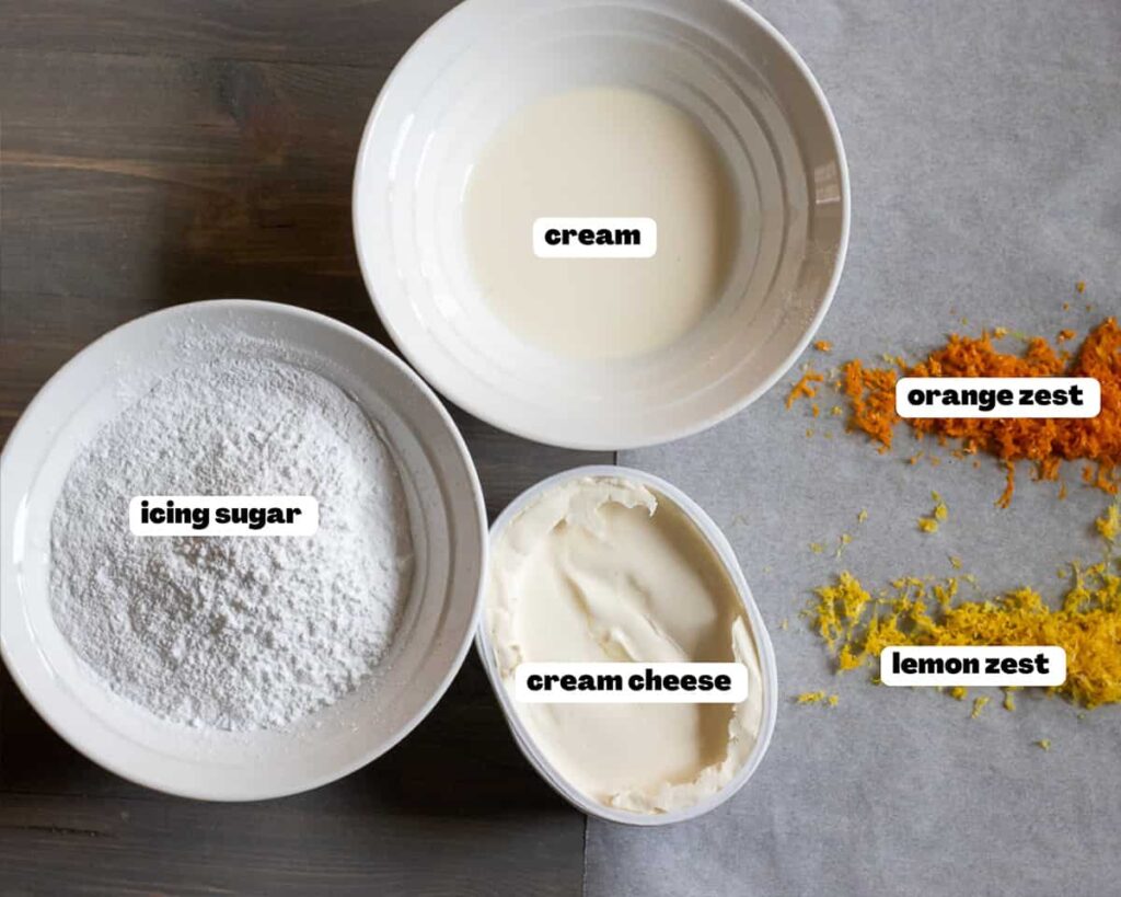 Ingredients for cream cheese frosting laid out on a countertop, including cream cheese, butter, powdered sugar, and vanilla extract, ready to be mixed into a smooth, creamy topping.