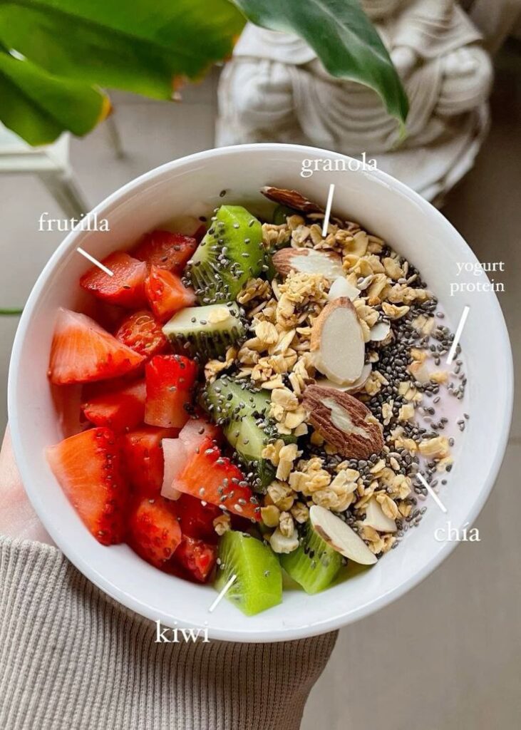 A bowl of Fruitilla, Granola, Yogurt Protein, Chia Seeds, and Kiwi mixed up for a healthy meal.