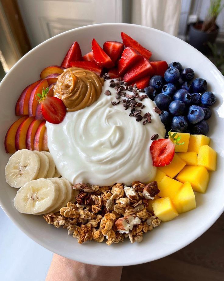 A wonderful preparation of oatmeal with different fruits in a white bowl.