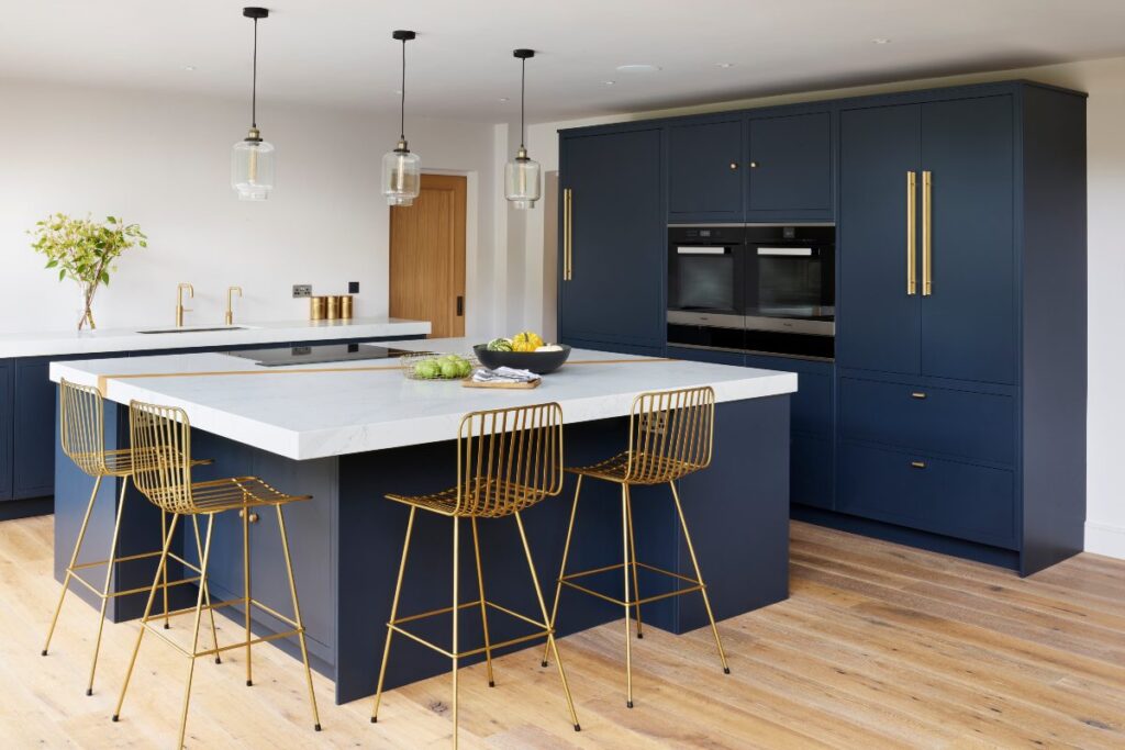 Dark Blue Cabinets are initiated in a well-planned setting with long chairs and wooden floors to match the color texture. 