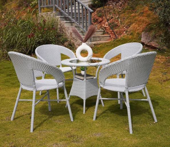 Round raised outdoor coffee table on a sunlit terrace, ready for outdoor meals.

