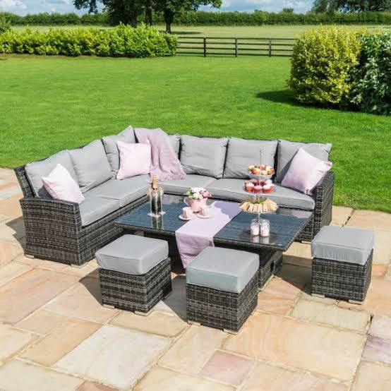 Compact outdoor coffee dining height table, surrounded by greenery in a garden setting.